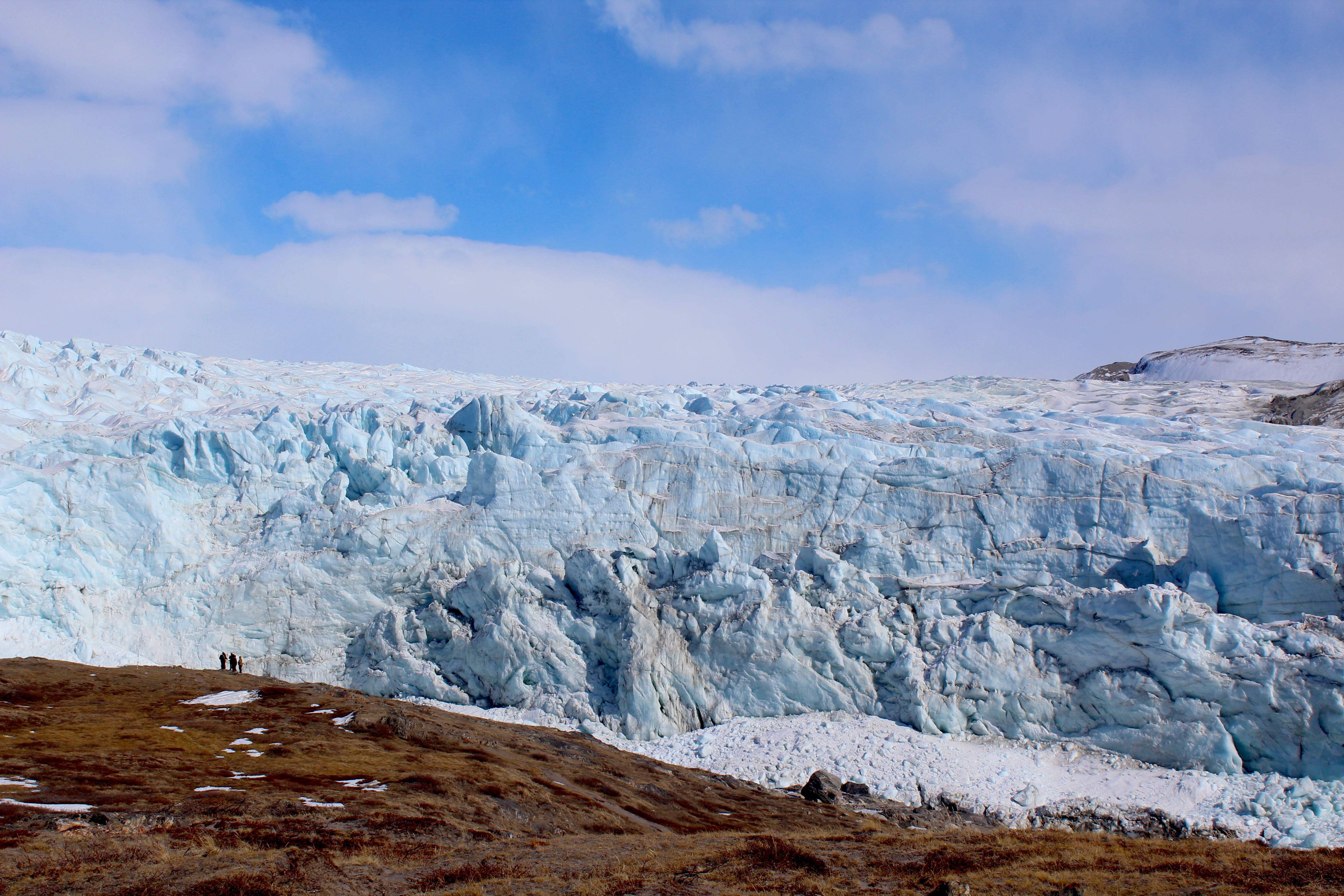 Field team looks on at the ice face of land-terminating Russell Glacier.