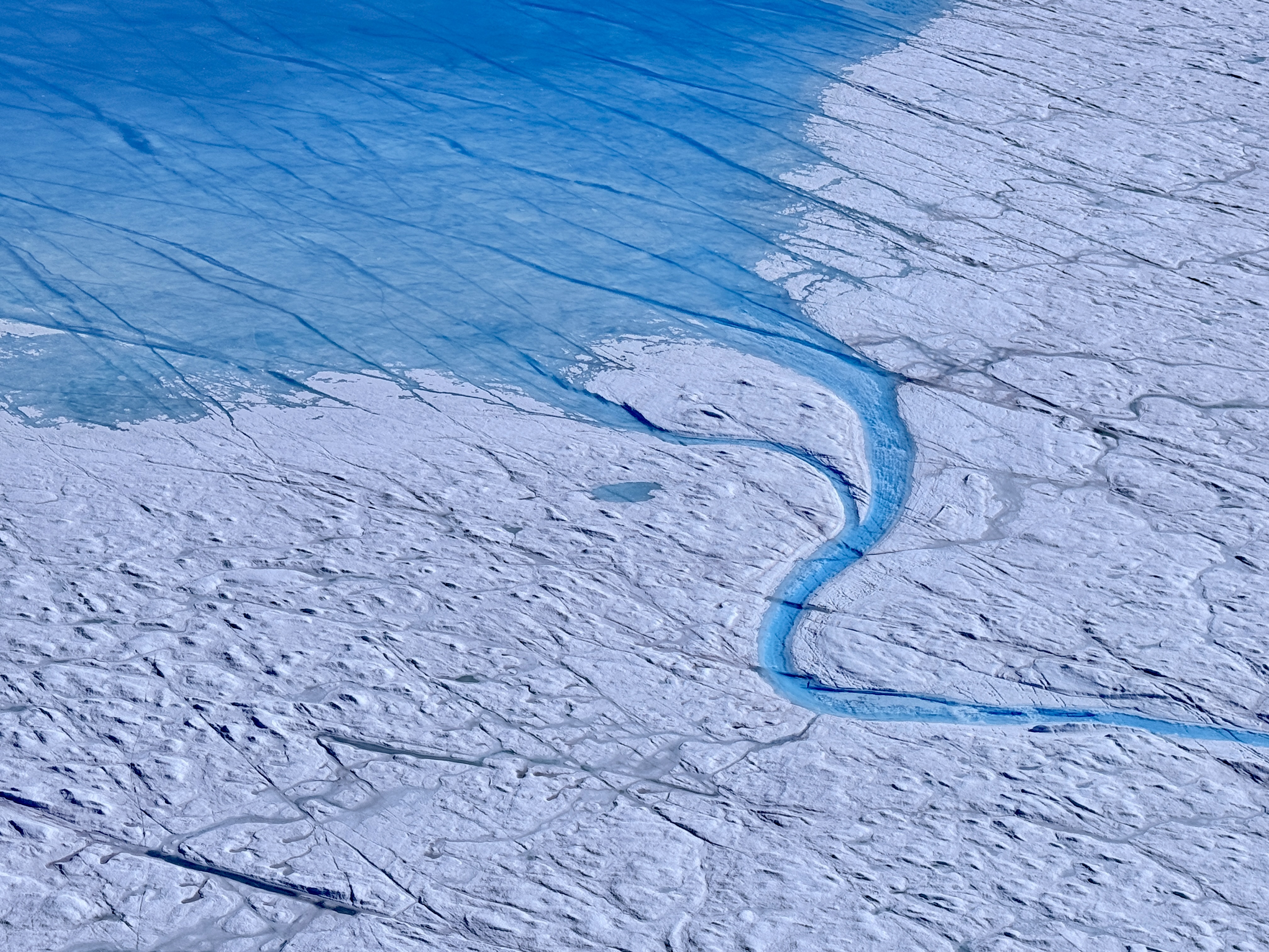 Meltwater channel carved into the ice sheet surface, Greenland.